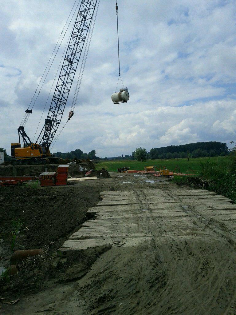 This almost feels like a video game: bike through the mud directly under a large metal tank marked "flammable" suspended by an...